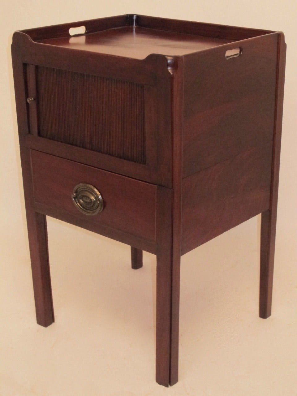 A fine Georgian period gentleman's commode or bedside table with tambour door and single drawer with lift up lid. England, circa 1820.