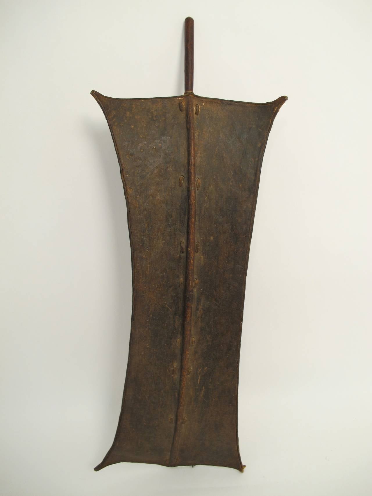 An early 20th century animal hide, wood and leather Toposa shield from Southern Sudan.