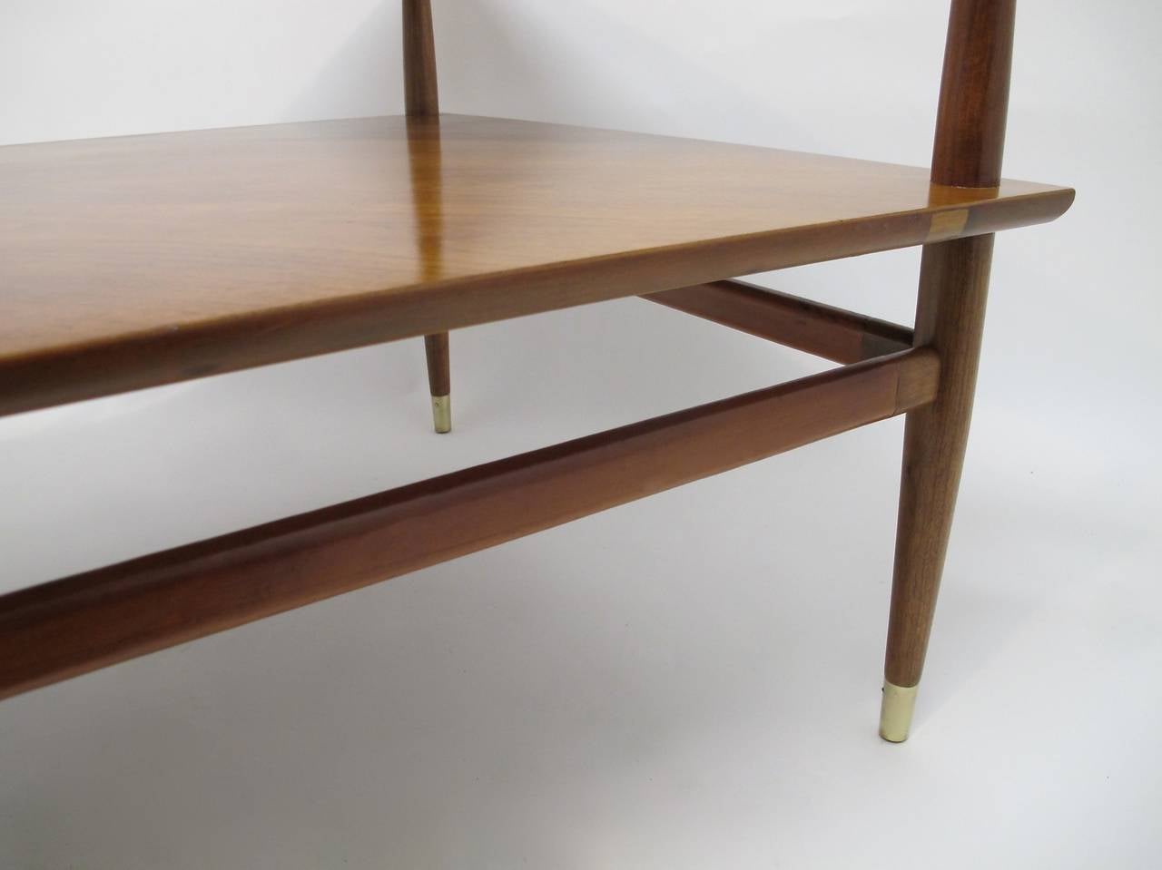 Henredon Mid Century Walnut and Leather Side Table. Top shelf is leather wrapped with exposed wood corners, as well as stretchers are partially leather wrapped. Tapered cylindrical legs ending with brass caps. Mid 20th century Henredon Heritage