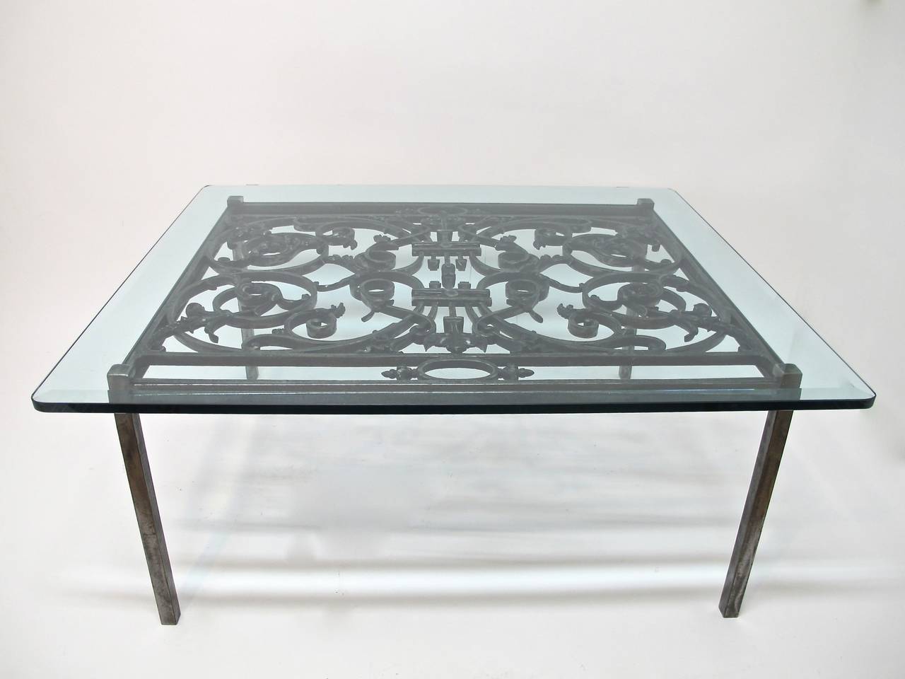 Custom made polished antique iron grate set into steel frame with beveled glass top. Glass top with 1