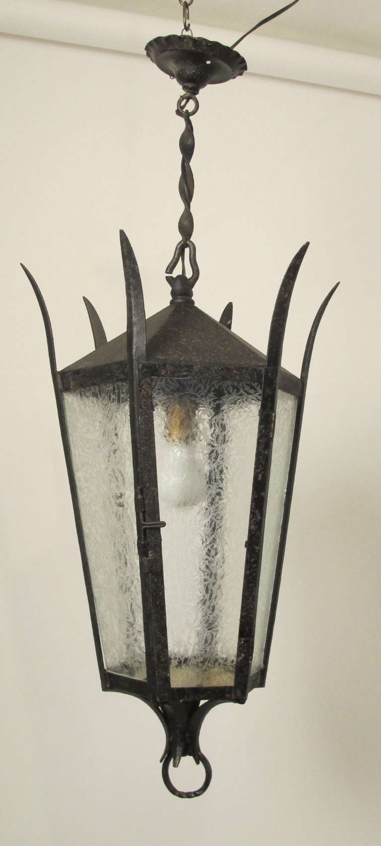 Octagonal Metal and Iron Hanging Lantern with textured glass panels and flared frawns at the top.  Length of chain from the top of lantern to the canopy 10
