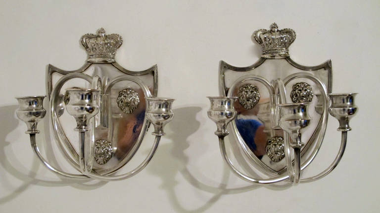 Pair of Sheffield silver plate wall sconces with three scrolling arms, lion masks mounted on the back plate and the top surmounted with crown. English, late 19th to early 20th century.