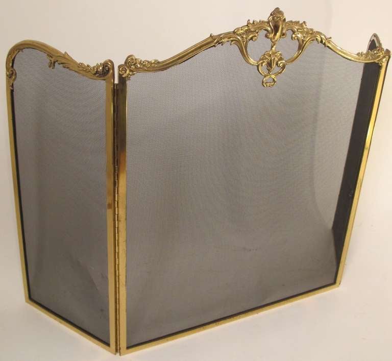 Tri Fold Solid Brass French Style Fireplace Screen, Custom Made by Wm. Jackson Co., New York, N.Y.  With Cast brass flowers, cartouche and piano hinged side panels.  Black wire meshing in perfect condition.  Mid Twentith Century.