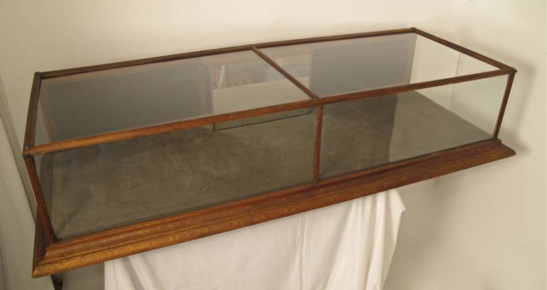 Oak display case with original cash compartment on back side, center mirrored section. Gray velvet lined and two tambour sliding back doors. Recently refinished.
Glass Case Dimensions-Height-12