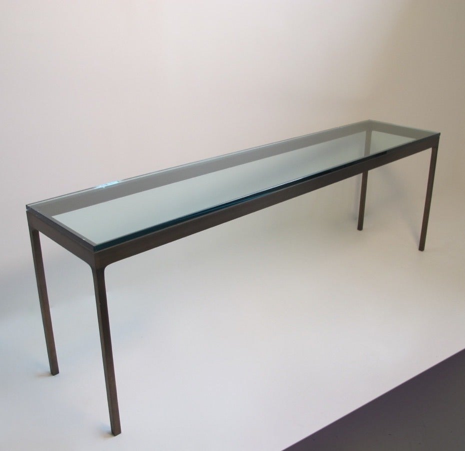 Brushed and patinated bronze console or sofa table with one inch thick glass plate top.