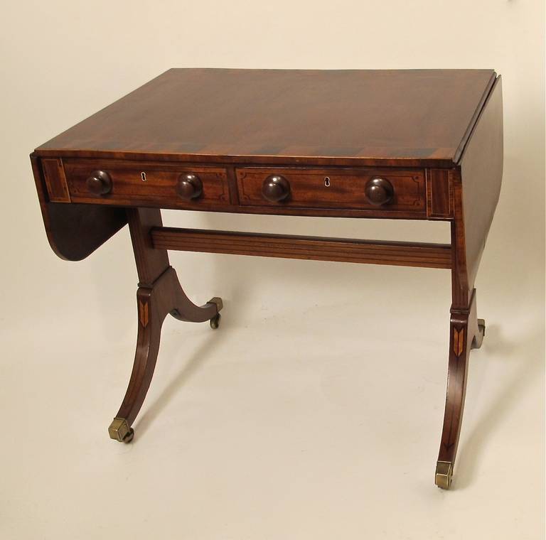 Mahogany and Rosewood sofa table with satinwood and ebony inlay detail on stretcher and supports. Table has one real and one false drawer on each side. Each side leaf measures 10.75 inches. In very good restored condition.