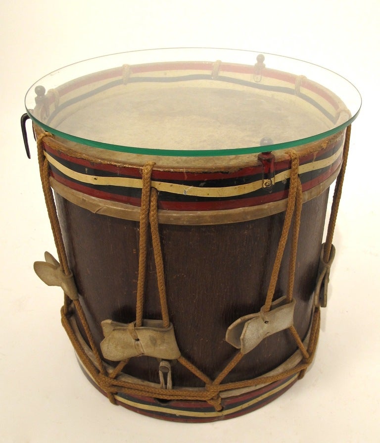 An antique marching drum with painted decoration. Makes for an interesting side table. Late 19th-to early 20th century.
