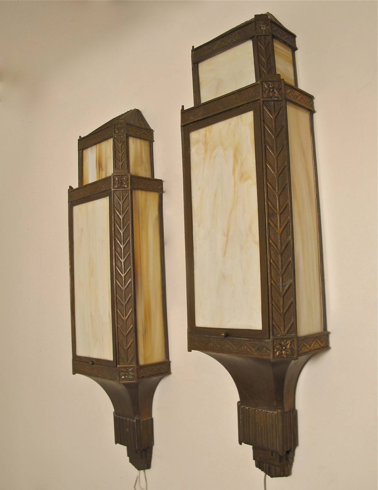 A large tower shaped pair of bronze and original caramel colored slag glass sconces. The front panel lifts up for access to the interior sockets. Newly rewired. American, 1920s-1930s.