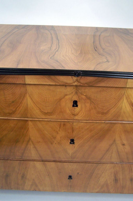 Commode à trois tiroirs de style Biedermeier en bois fruitier du XIXe siècle avec détails ébénisés. État original avec une belle finition ancienne.