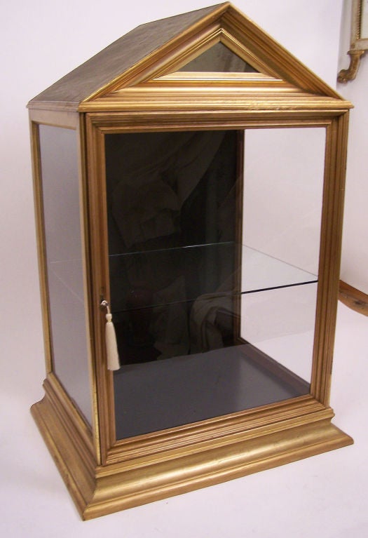 Old display case made from 19th century water gilt frames. Has glass sides, one shelf, and mirror detail at the top. It is electrified with one bulb. This case was most likely made in the late 19th-early 20th century.