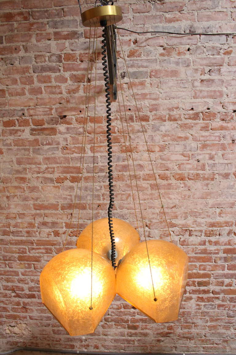  Italian designer Salvatore Gregorietti. The pendant is build op on three large resin shades. The metal wires create a beautiful composition to the brass canopy. The brass is nicely repeated in the edges of the fiberglass shades, which gives them