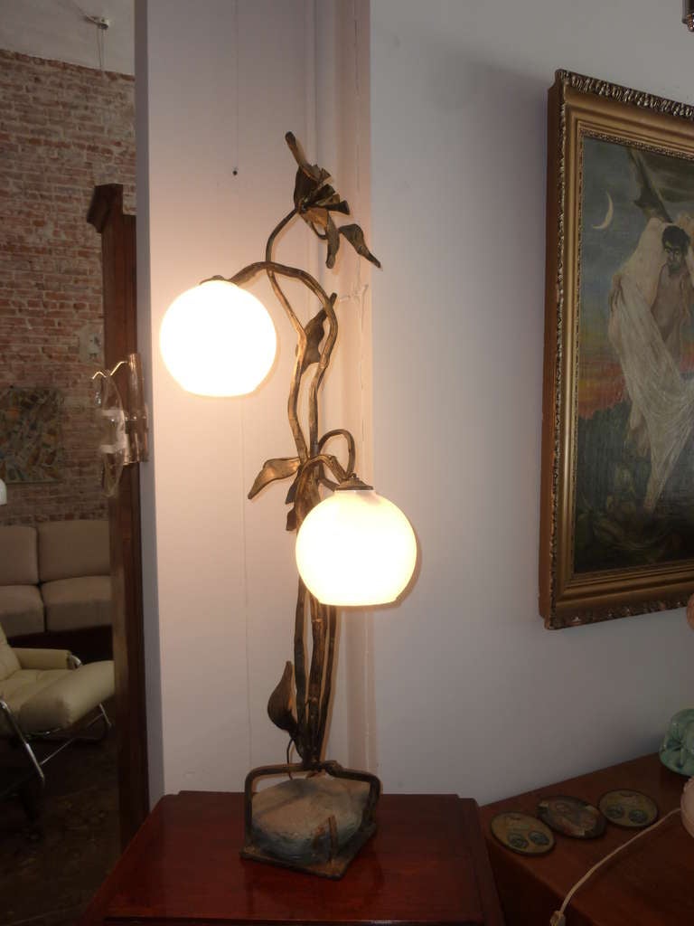 L'artiste vénitien Gimo Fero a conçu et fabriqué cette lampe à la main. Une grande base sculptée en fer forgé et le verre de lait.
Il s'agit d'une grande lampe de table qui peut être utilisée comme lampadaire.