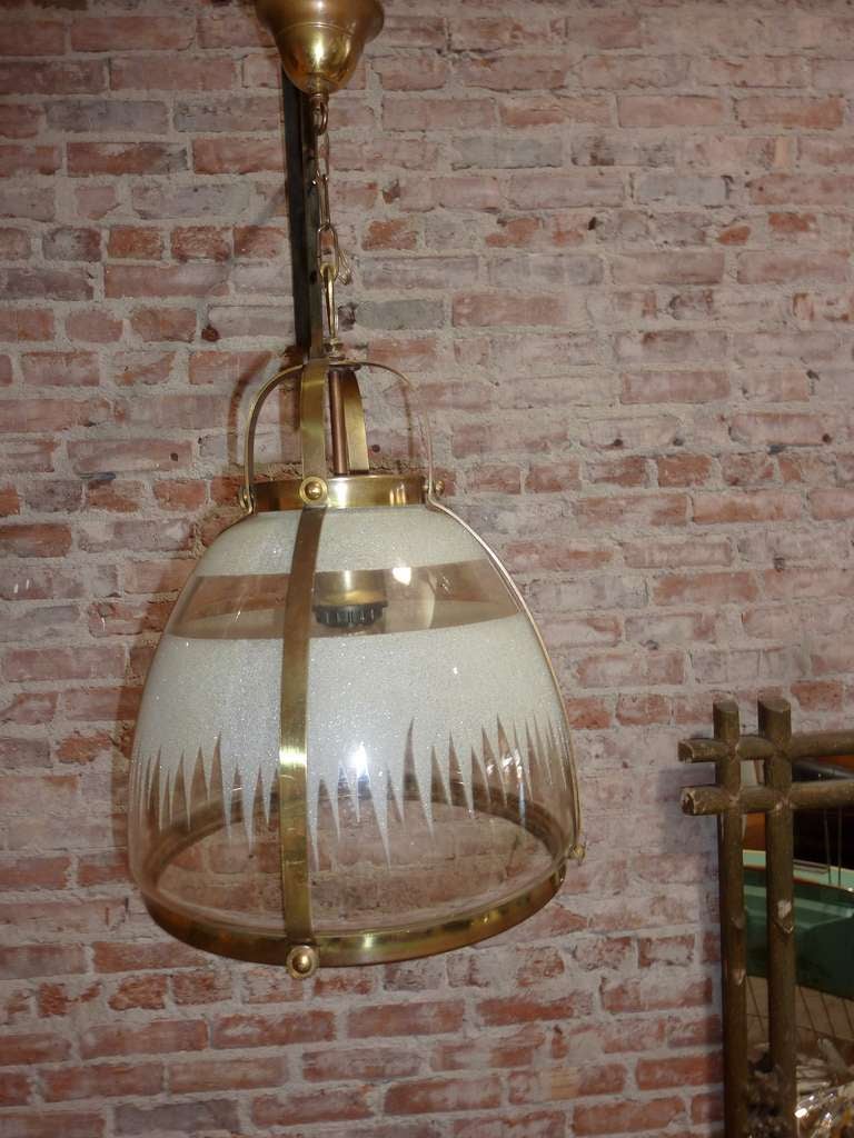 Brass and fume glass chandeliers. Part of the glass shade  is etched all together gorgeous.