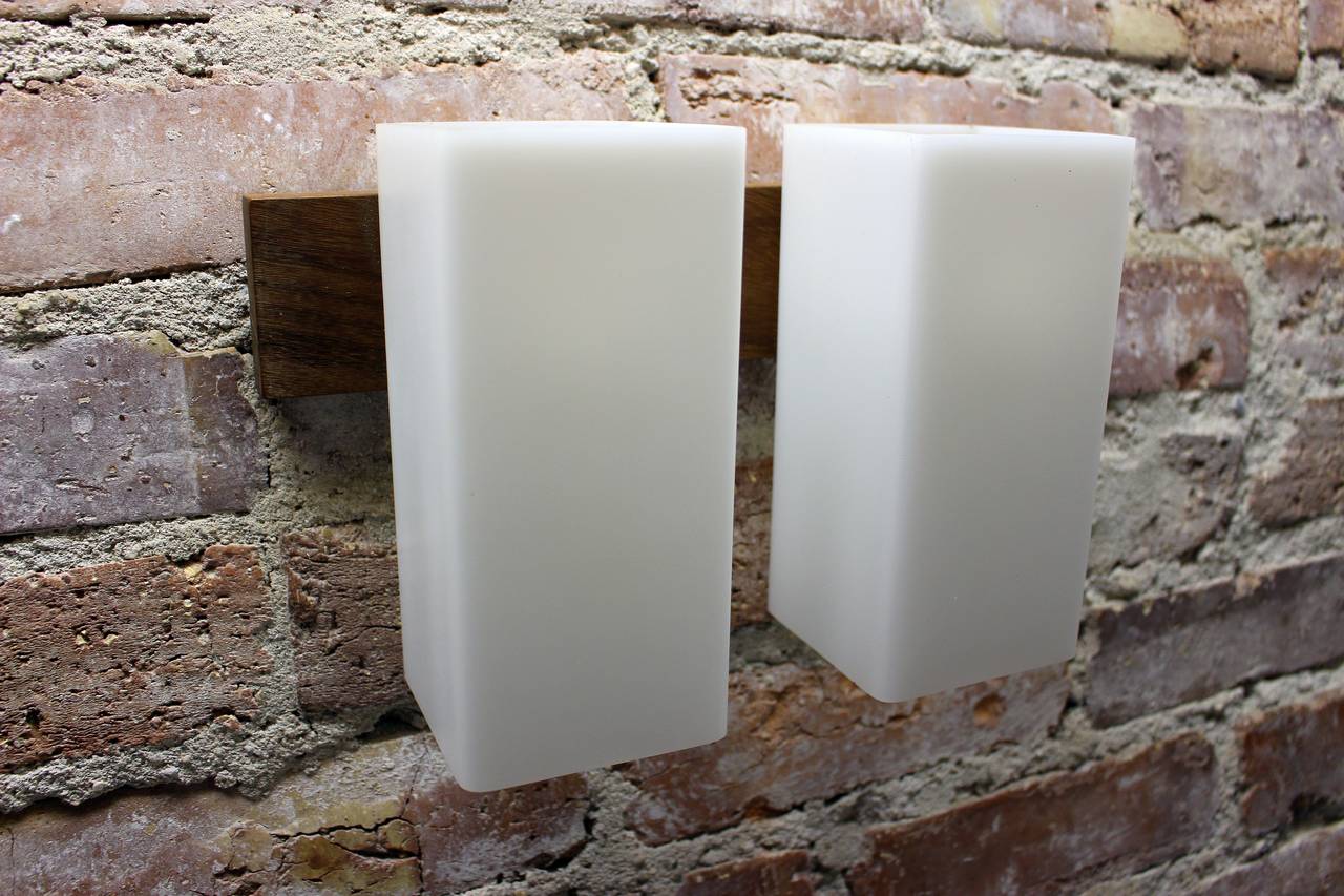 Pair of wall sconces teakwood base and the plastic shade.