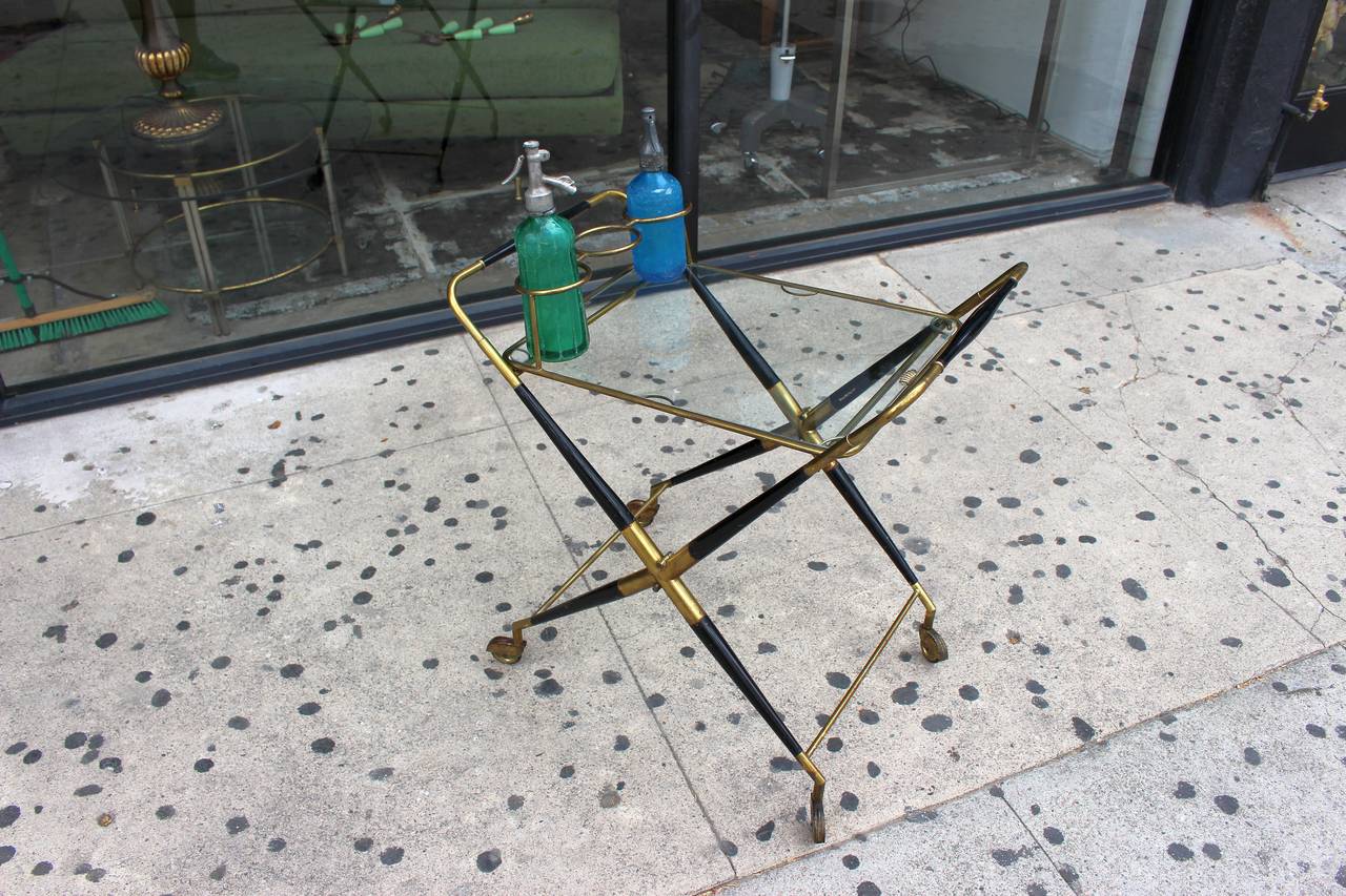 Italian Cesare Lacca solid brass, ebonized mahogany and glass, on casters. Brass ring bottle holders, bar cart can be reassemble for easy shipping and storing.
USA continental in home delivery $250 2-4 weeks
  expect winter holydays 