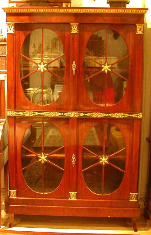 An Neoclassic Empire mahogany bookcase with parcel-gilt.