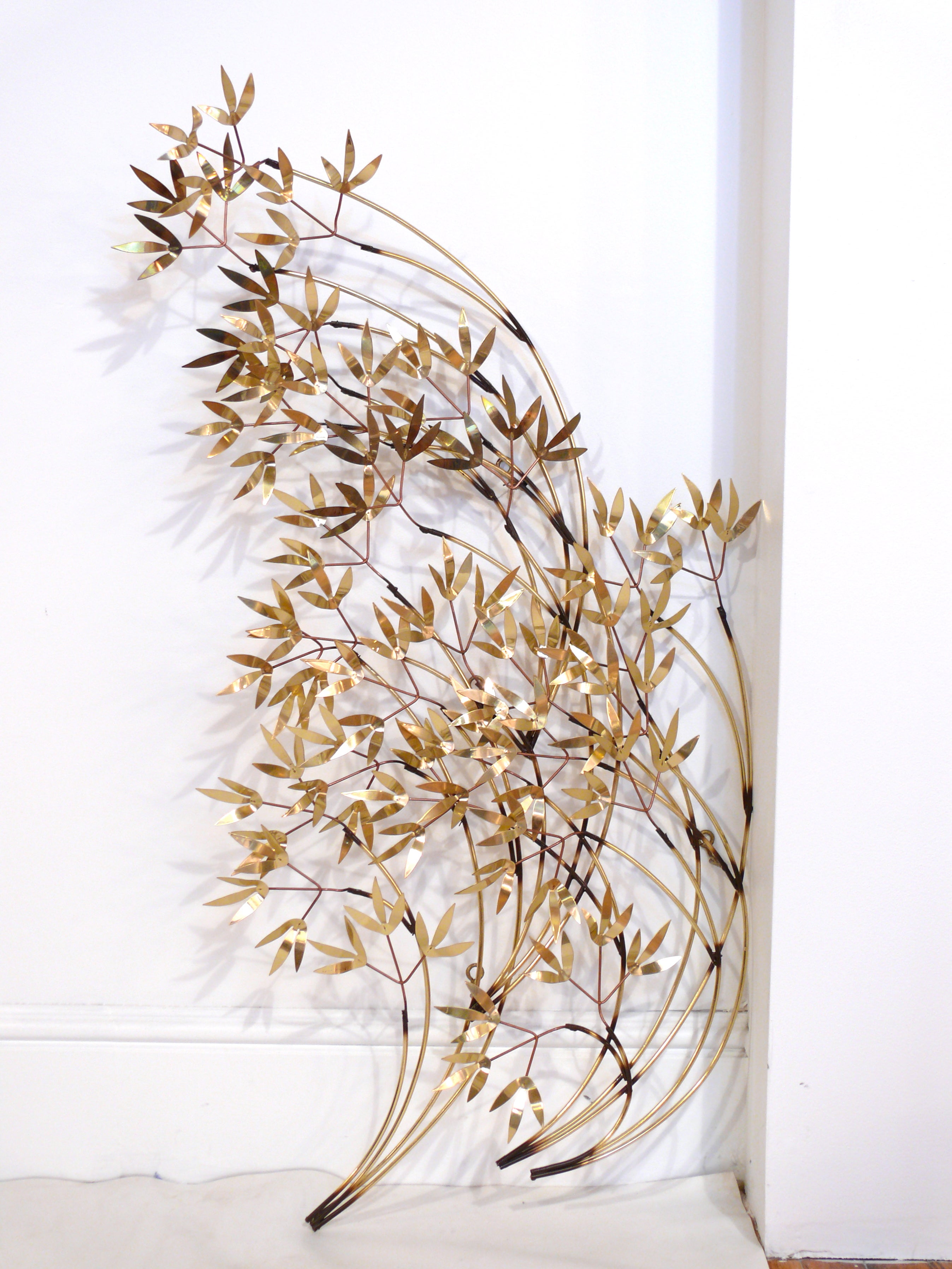 Wall sculpture by Curtis Jere, signed and dated 1983. Cascads of leaves flow seamlessly to create a windswept appearance. Can be hung horizontally or vertically.