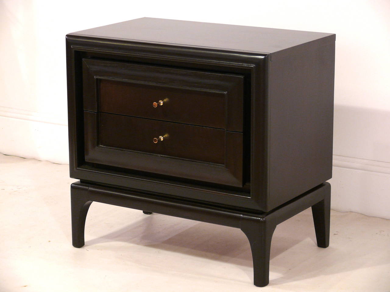 Mid-Century Modern two-drawer end tables with projected outer frames. The case rests over beautifully sculpted legs. Newly refinished in a deep satin finished espresso over walnut.