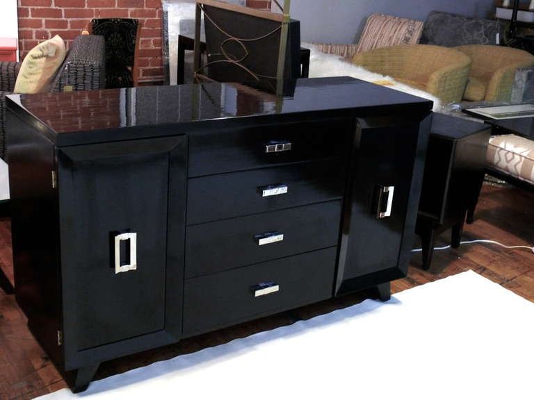 Elegant Mid-Century Modern credenza with ebonized finish. The credenza has
four center drawers and two side doors which have drawers inside of them.
The hardware has been plated in nickel. There is some wear and cracking to the finish on the  side