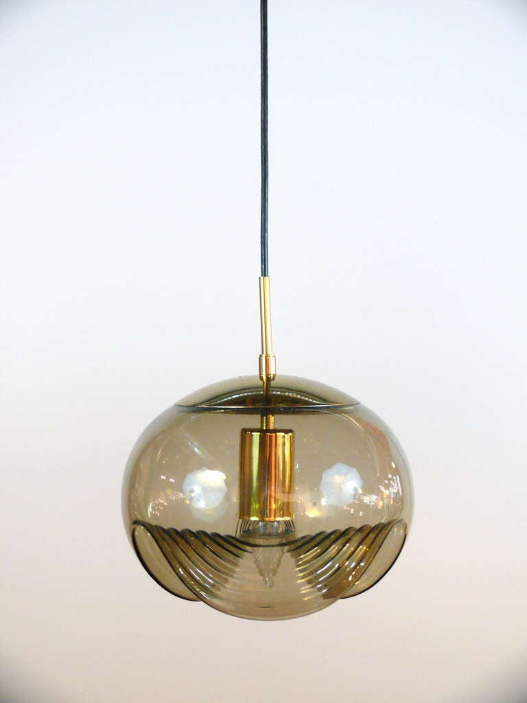 Pair of pendants attributed to Fontana Arte.  Hand blown smoked glass pendants suspended from a brass bar.  Can be separated into two hanging globes.