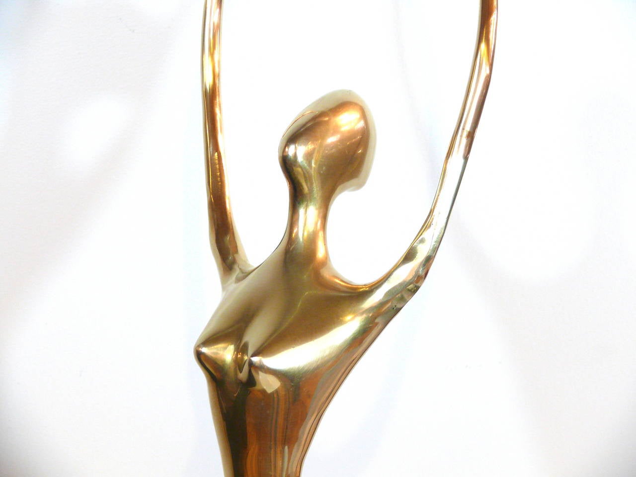 Gorgeous Mid-Century tall brass sculpture of a woman figure resembling a dance stance resting over a brass base.