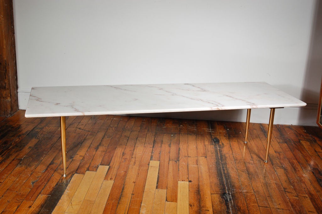 This white marble table showcases beautiful white marble stone with beautifully shaped brass legs.