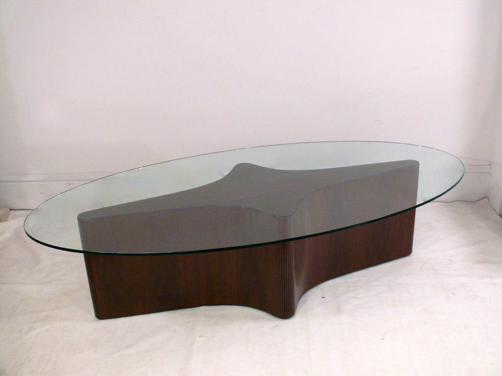 Beautiful star shaped coffee/cocktail table in a deep chocolate finish reminiscent of the work of Vladmir Kagan. The perimeter of the table is tamboured to accept the star shape and is topped with a gleaming oval glass top.

Glass top