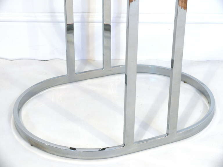 Elegant flat bar chrome side table, 1970 in the manner of Milo Baughman. Double risers add both structural and visual interest. Original oval glass top included.