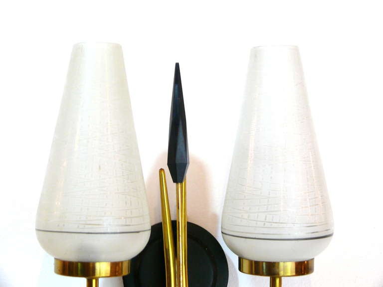 Pair of brass and glass sconces in the manner of Jean Royere. Each sconce has two lights and a center spear. The glass is etched in a criss-cross manner with a frosted base. 