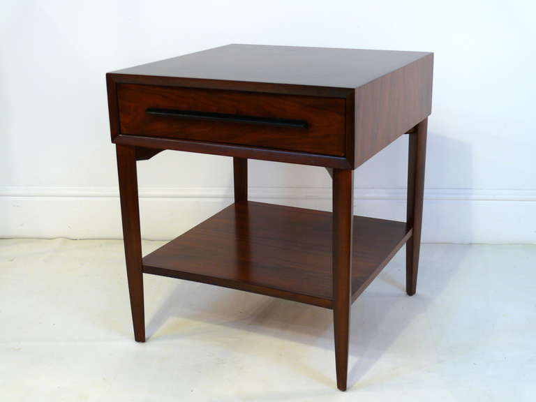 Pair of 2 tiered Widdicomb night stands finished in a medium walnut with gorgeous visible grain.  The front curved drawers featuring elongated ebonized pulls on brass stand offs give these pieces the perfect touch of elegance.