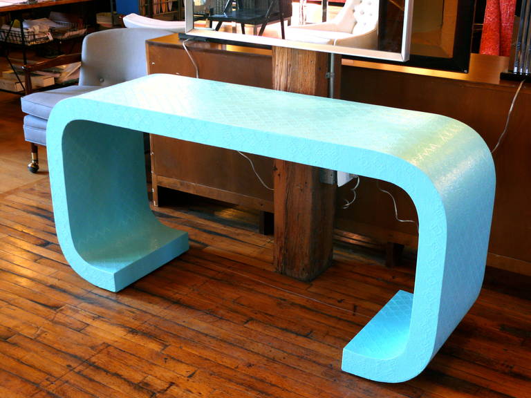 Modernist console table in the manner of Karl Springer. Covered in grasscloth, this console is newly lacquered in Tiffany Blue for a gleaming, fantastic finish.