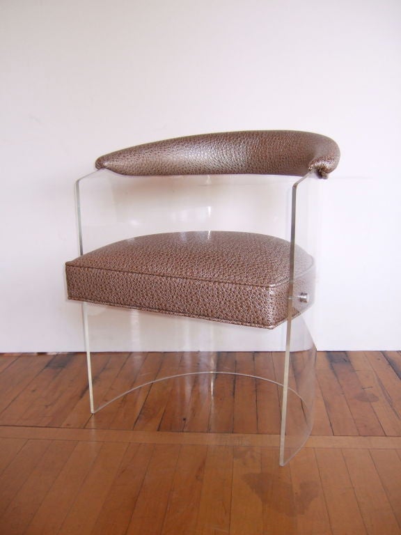Four fabulous lucite barrel chairs upholstered metallic faux leather.  Made by Hill Manufacturing.  Faux leather backrest trim and seats, these artistically curved armchairs are comfortable and delight to enjoy.