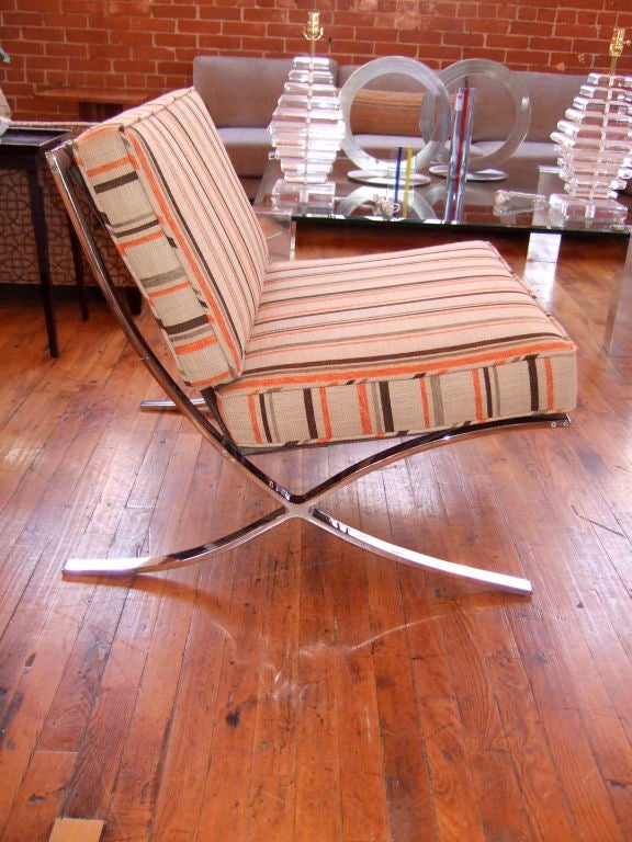Single Barcelona style chair.  This Barcelona chair has a chrome plated steel frame. The chair has been newly reupholstered, but retains the original brown leather straps, making it super comfortable.