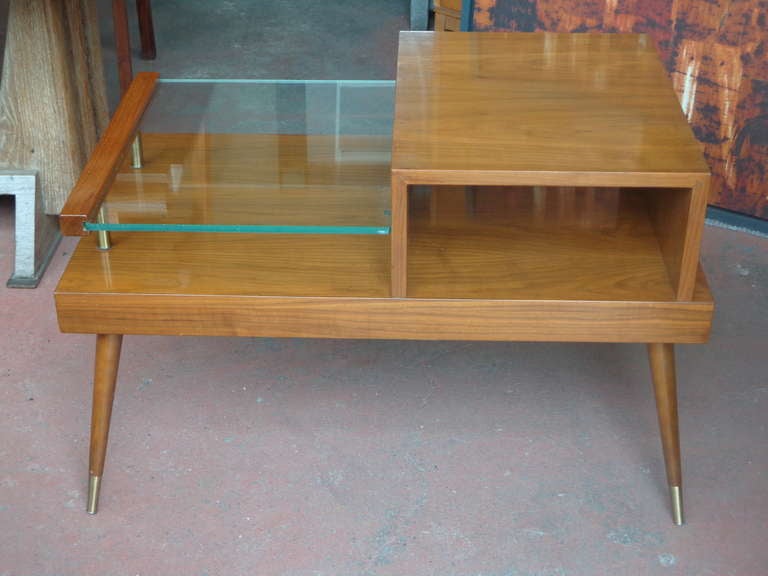 Pair of walnut veneer tiered side tables with original maker labels and stamped 1956. With glass shelf and brass detail.