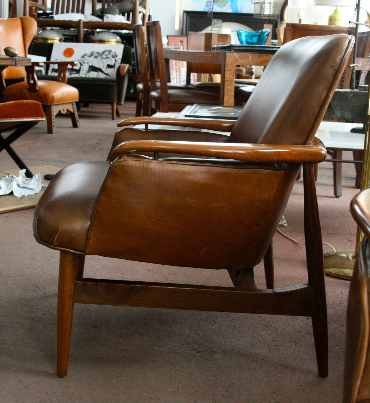 Pair of substantial 1950s Italian leather chairs, in solid walnut, brass detail on armrests.