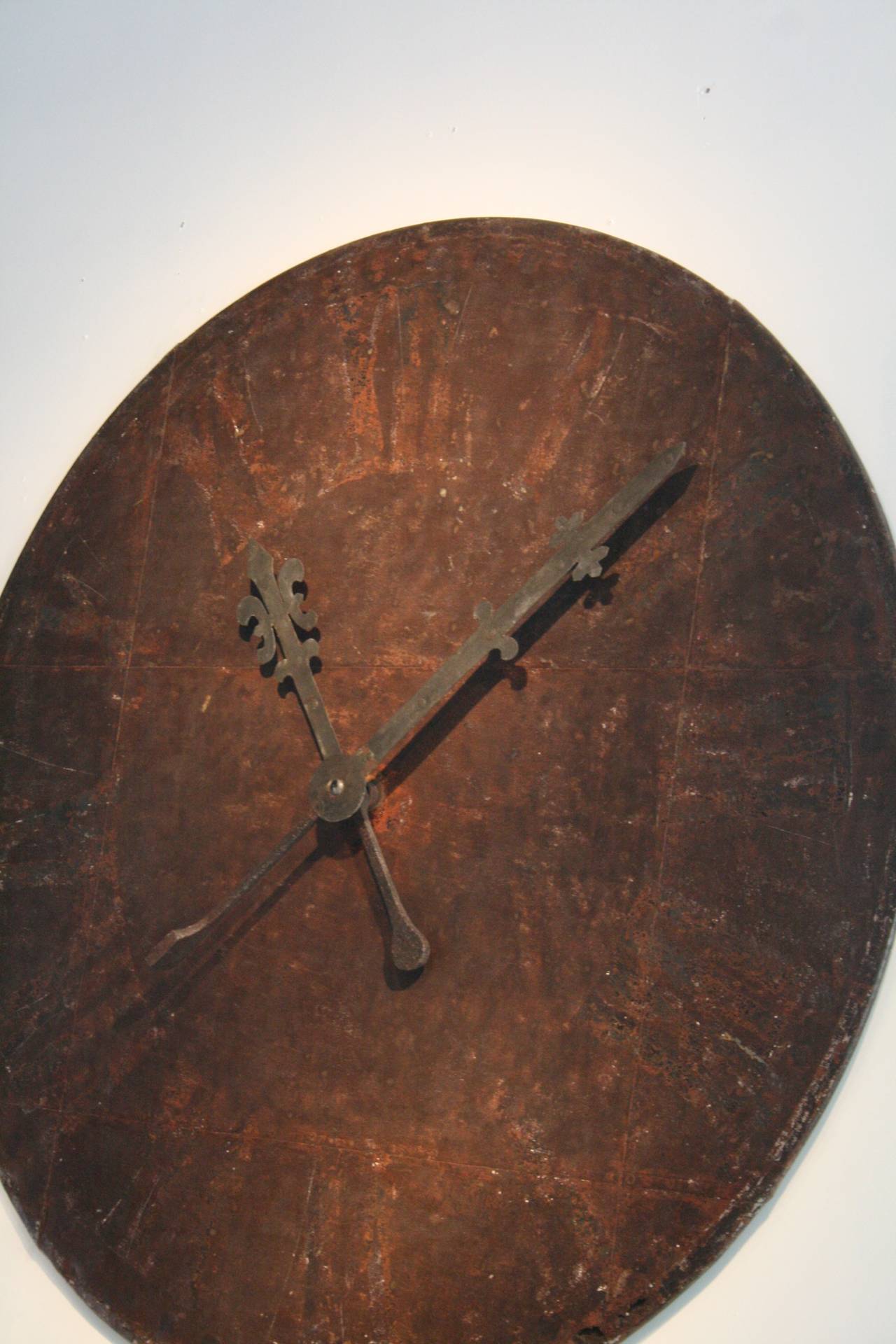 Beautifully faded painted metal clock face from Northern France, with original forged iron hands.