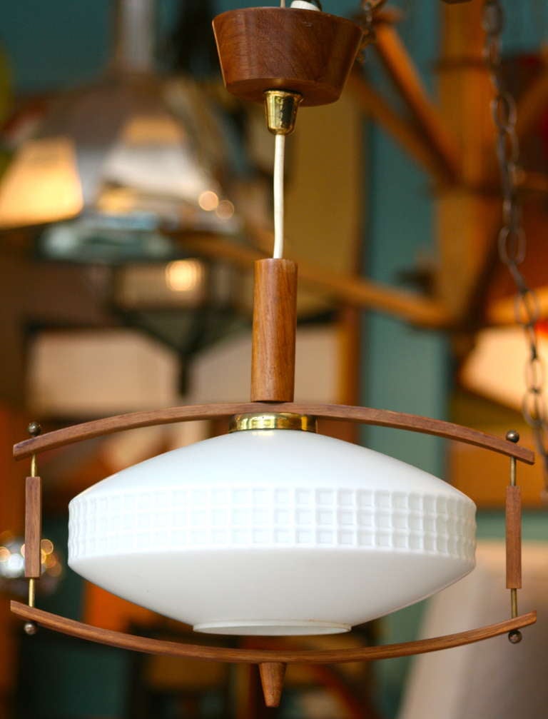 As seen in the recent episode of Mad Men, charming Danish teak pendant light with milk glass shade.