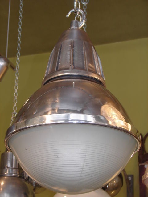 Polished steel french factory lights with original holophane glass. 4 available. wiring for US included.