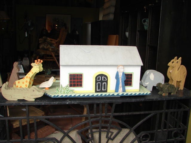 Large hand crafted painted wooden Noah's Ark, originally created for a designer showhouse display. 7 attached pairs of animals,(giraffes, elephants, kangaroos, camels, crocodiles, turtles, ducks), Noah and a plant cluster. Ark roof opens up in the