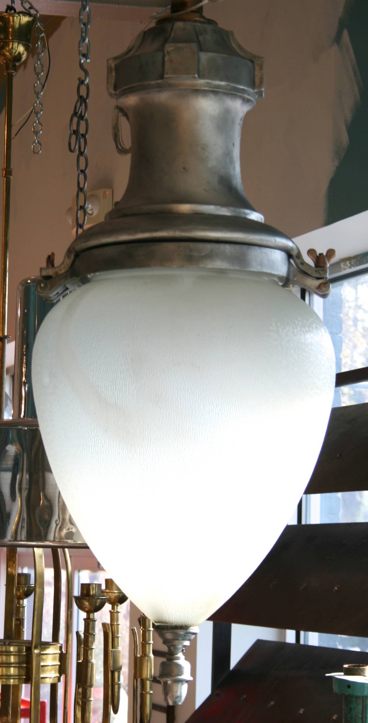 Large-scale cast aluminum pendant light with original patterned glass shade, bronze detail. An identical one is available with glass that has a lavender hue.