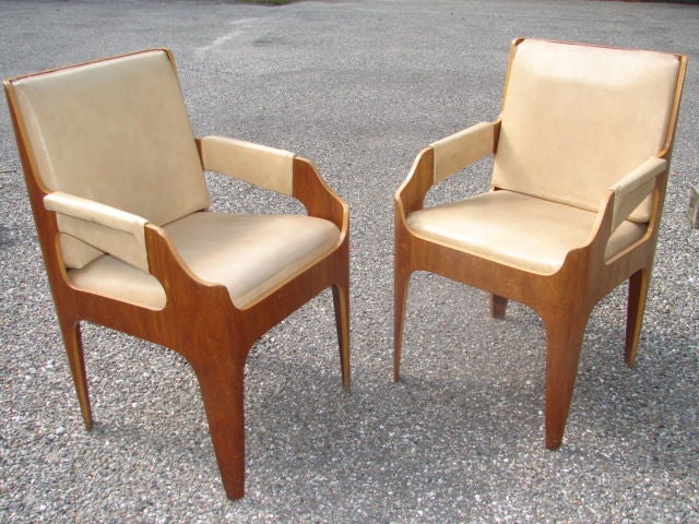 A rare pair of documented mahogany veneer molded plywood armchairs, designed by UK designer John Wright in 1960 for the Wagoner Room on the SS Canberra cruise ship. These chairs appeared in several variations on the ship, along with other