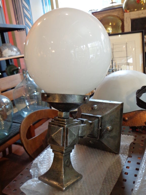 Bold geometric arts and crafts cast iron arm lights, with new sphere glass shades, 2 pairs available. Priced per pair. measurements are without shade.