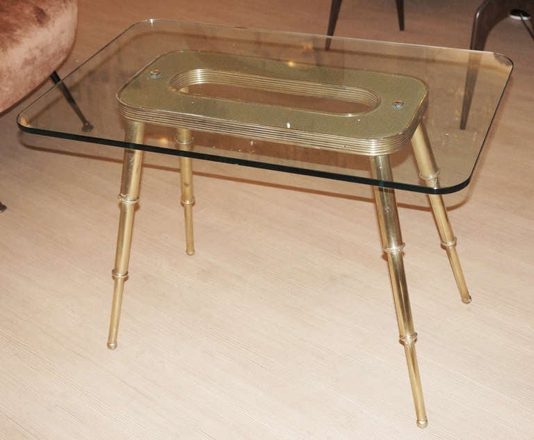 Very elegant Italian side table with a light brass structure that supports a thick glass. The details make the difference: the finely embossed brass surface under the glass and the 3 levels slanted legs.