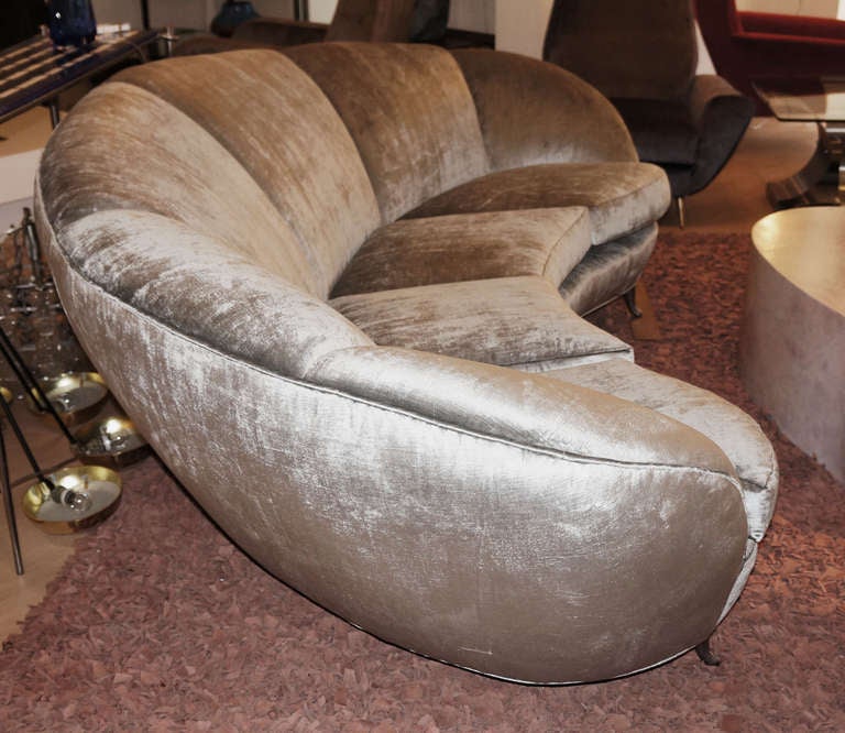 Excellent Italian late 40's early 50's curved sofa. The large size as well as the striking design set this sofa apart. The shoulder rest is divided in 6 sections and has 4 shaped pillows. The sofa rests on 5 polished aluminum curved feet, Just