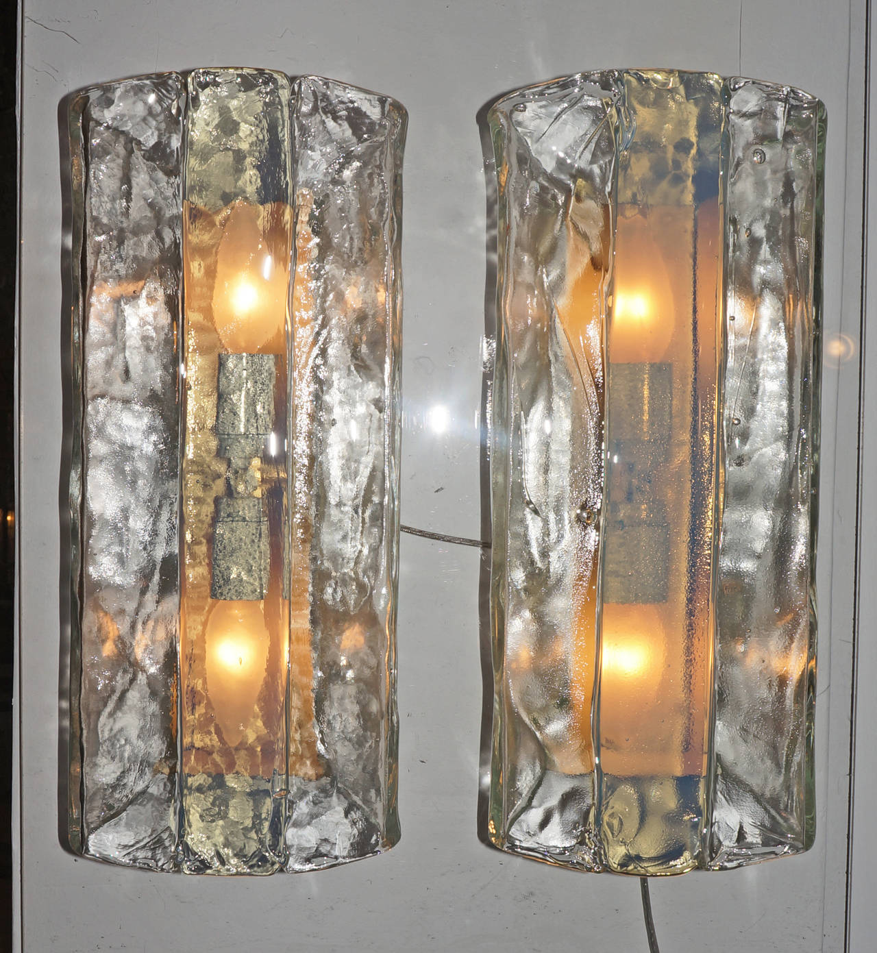 Large pair of Mazzega sconces probably designed by Nason. It features a rich texture clear glass on the sides and a very light blue stripe in the middle. It has two sockets.