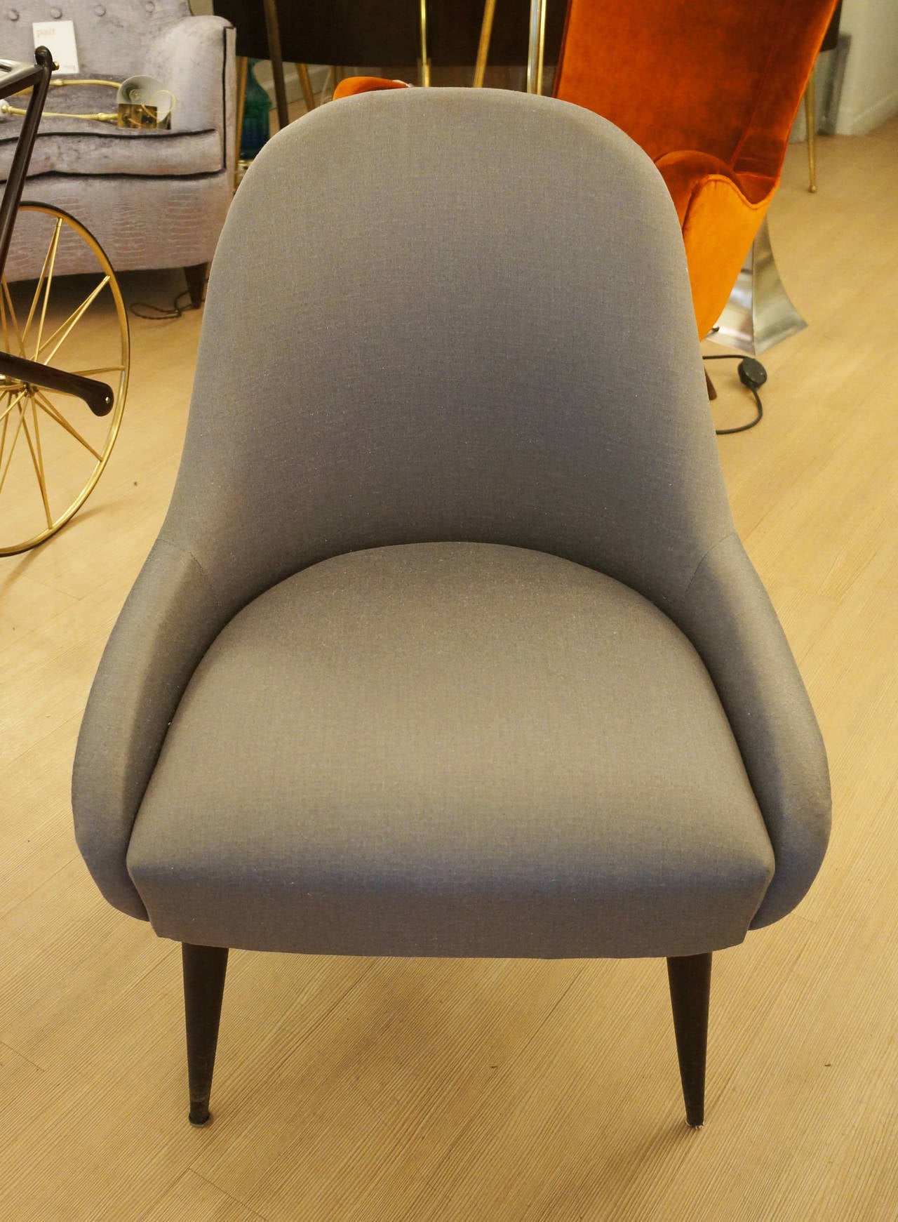 Pair of Italian 1950s sleeper chairs re-upholstered in a gray cotton. Legs stained ebony.