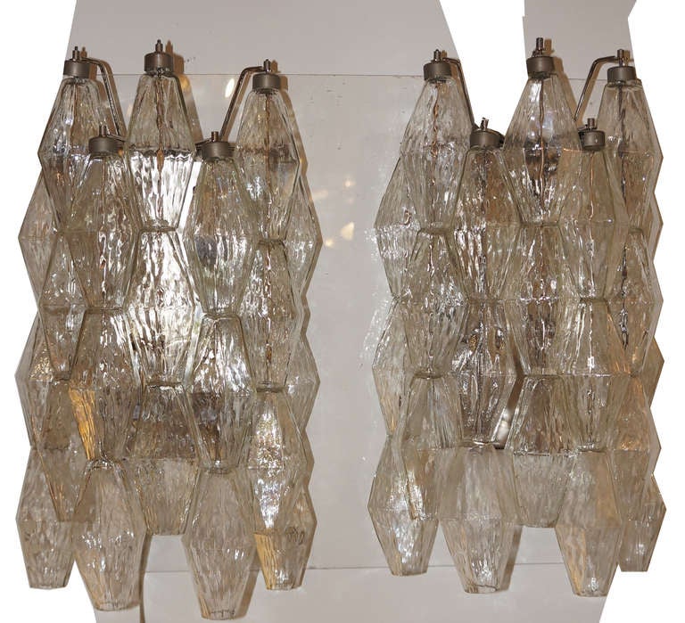 Fourtytwo clear hand blown shaped glass hang from a nickel plated metal structure. The surface of each polyhedral glass has a nice texture. Four candelabra light sockets for each fixture make a wonderful light. Unmarked