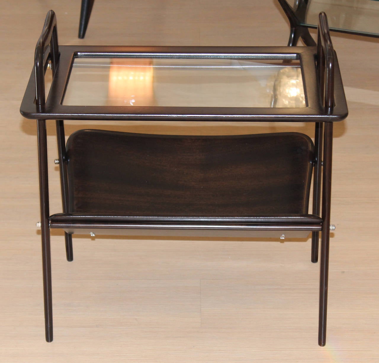 Elegant Italian Mid-Century side table that functions also as a magazine stand and drink serving tray. The top is the removable tray that fits through two slots or handles in the table. The angular wood lower level is the magazine stand.