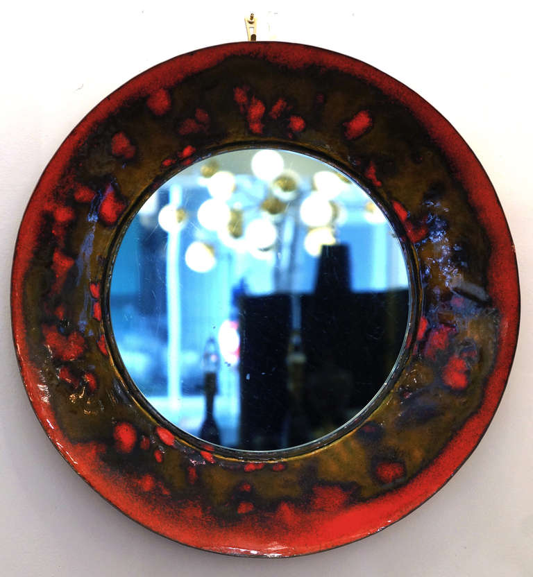 A very special and cheerful mirror enamel coated in an abstract pattern with vivid red and earth tones. The mirror is darkened. A good example of the great Italian enamel coating arts of the mid-century period