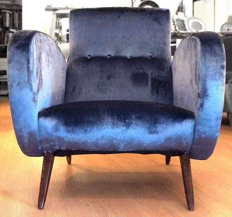 A striking and  rare design that reminds somehow of the armchairs designed by Carlo Mollino for the Rai Auditorium in Turin re-upholstered in violet velvet